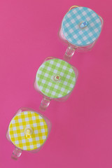 Creative look at the colored jars for a summer cold drink on a pink background.