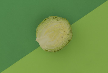 Fresh green cabbage on a background of similar (analogous colors) shades of green.