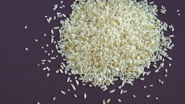 Brown and white rice grains. Food background. Close up rotation