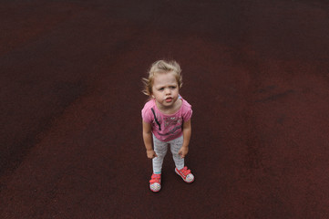 Fototapeta premium capricious little girl on a dark red background