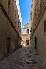 Scenic narrow alley in Monopoli old town, Apulia, Italy