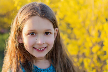  Portrait of a girl in yellow flowers. Little girl in a green dress