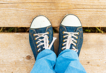 legs in sneakers on a wooden floor