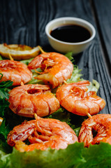 Large grilled BBQ shrimp with sweet chili sauce and lemon, salad.parsley dill celery skewer, dark background, shrimps prawns skewers with herbs