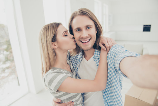 New place of living! Buy buyer owner customer concept. Close up portrait of handsome bearded with toothy beaming smile making taking self picture lady giving kiss to her wealthy rich beloved guy
