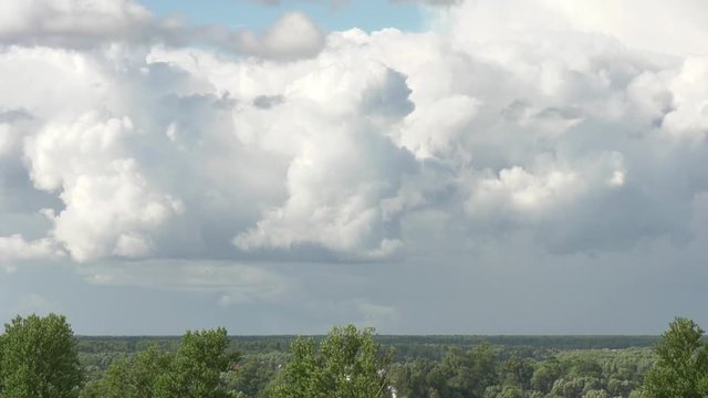 Large cumulus clouds above the ground. Time lapse