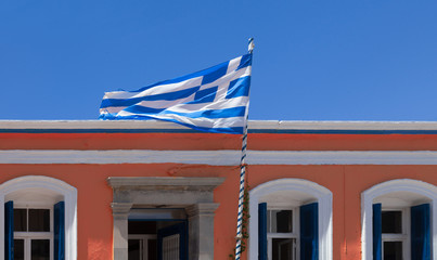 Fototapeta na wymiar Greek flag and traditional building