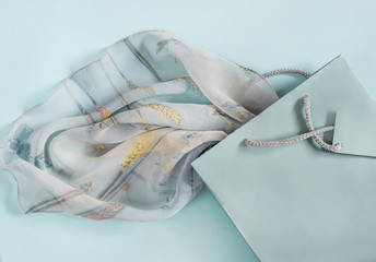 gift bag with a handle, part of a dress on a turquoise background