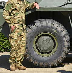 Soldier stands next to an armored military vehicle