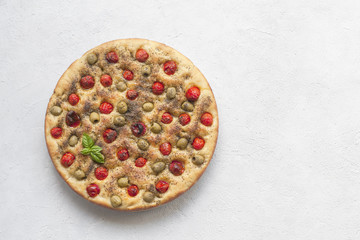 Homemade oven-baked  italian  focaccia - focaccia Barese, with olives, olive oil, tomatoes, herbs