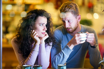 Young attractive couple having problems on date