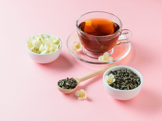Herbal tea, honey, Jasmine flowers and a wooden spoon on a pink table. The composition of the morning Breakfast. Pastel color.
