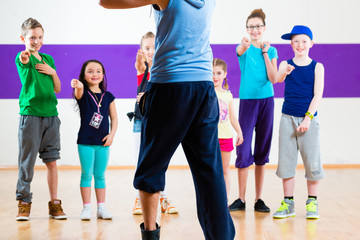 Fototapeta na wymiar Dance teacher giving children fitness class in gym