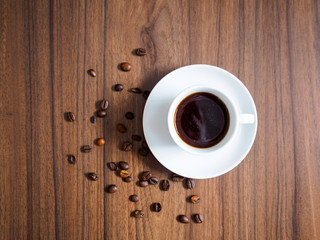 Espresso auf einem braunen Holztisch und Kaffeebohnen