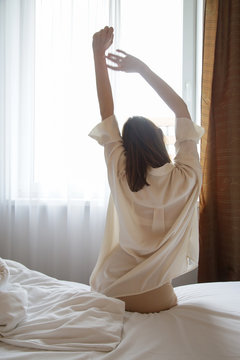 Woman streching in the bed, waking up in the morning,  still sleepy, lazy or tired