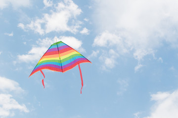 A floating kite in colors lgbt against the sky.
