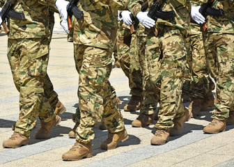 Soldiers marching with machine guns in hand
