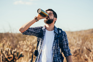 Man taking a break to drink from water bottle while hiking at Brazilian Caatinga