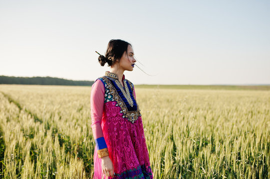 Tender indian girl in saree, with violet lips make up posed at field in sunset. Fashionable india model.