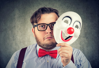 Unhappy man covering feelings with mask