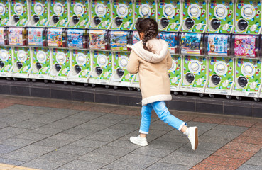 Fototapeta na wymiar TOKYO, JAPAN - NOVEMBER 7, 2017: The girl runs along the city street. Copy space for text.