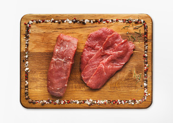 Raw beef filet mignon steaks on wooden board, isolated