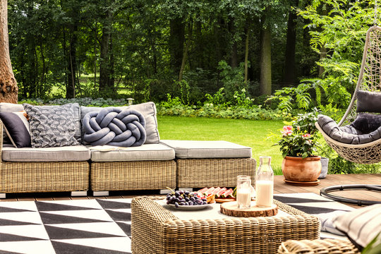 Milk and grapes on a table, sofa with knot pillow and geometrical carpet on a terrace in spa