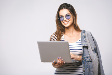 Portrait of happy young beautiful smiling woman standing with laptop isolated on white background. Space for text.