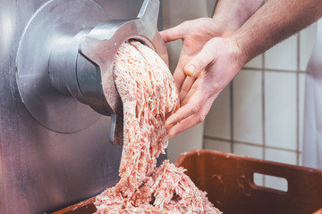 Minced meat flowing out of grinder in butchery