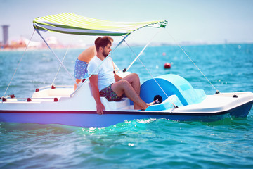 Naklejka premium happy family, father and son enjoy sea adventure on watercraft catamaran at summer vacation
