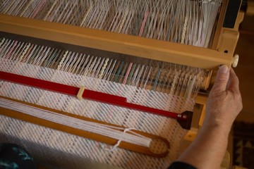 Senior woman weaving silk at shop