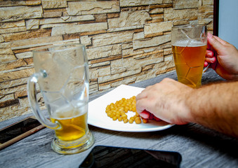 Friends sit in a bar. Men's hands holding a glass of beer.