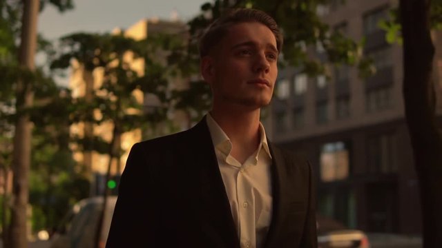 Young businessman is walking down the street. Confident man wearing suit goes to a meeting.