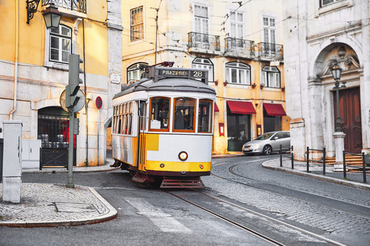 Lisbon, Portugal. Vintage yellow retro tram on narrow bystreet © Yasonya