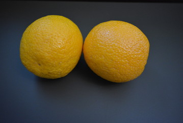 Fresh fruits, two orange oranges on a glossy black background