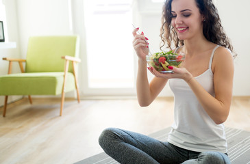 Fitness woman eating healthy food after workout - obrazy, fototapety, plakaty