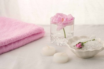 Spa resort therapy composition. Candles, rose flower, salt, towel. Relax, wellness and mindfulness concept
