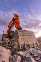 Large orange excavator in the construction works of the Madrid-Segovia-Valladolid highway (Spain)
