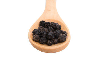 black dried pepper in wooden spoon isolated on the white