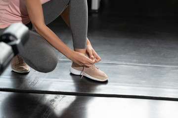 Fototapeta na wymiar Get up and exercise in your life. Running shoes - woman tying her shoes getting ready for exercise in the gym. Living healthy lifestyle concept...