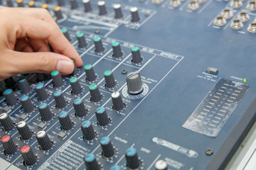 Hand adjusting audio mixer