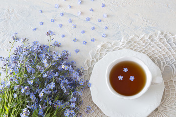 bouquet of flowers forget me nots and tea  on a light table
