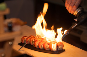the cook prepares sushi with  fire