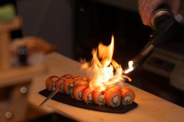 the cook prepares sushi with  fire