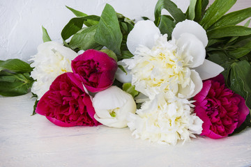 a bouquet of white and pink peonies lies on a table