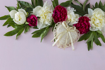 on a pink background peonies and a heart made of lace