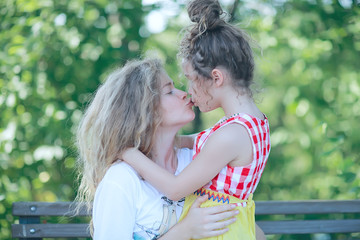 daughter kisses mom / happy family mom and daughter kiss, concept of female happiness, beautiful mother and daughter 5 year old kiss