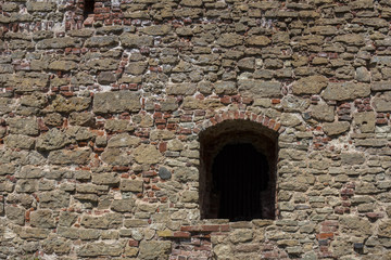 The wall of the house of the old stone and the window in it