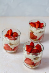Strawberry tiramisu. Glasses. Silver spoons. Light background. 
