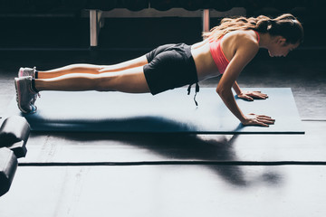 Attractive Yong woman doing yoga on yoga mat at the gym.